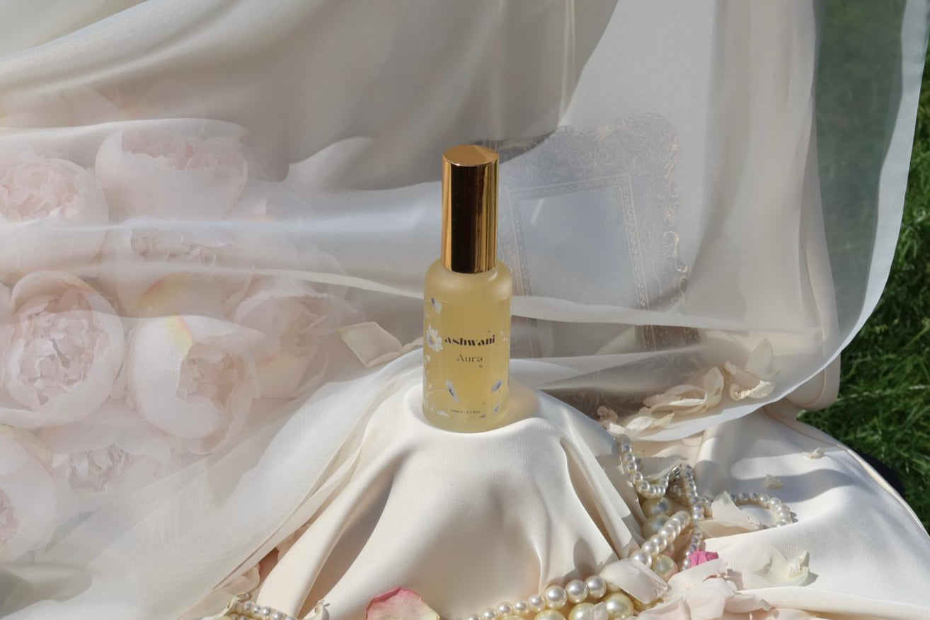 Perfume bottle on a white dress with floral and jewelry details